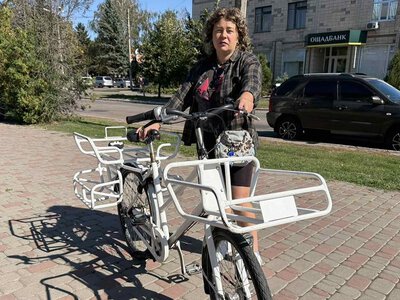 Соціальна працівниця тестує велосипед: подарували бельгійці
