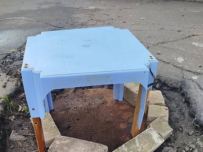 Цегла, металевий лист і стіл: у Миколаєві каналізаційний люк облаштували на дивний лад (фото)